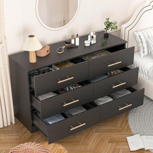 Black dresser with drawers open and gold-tone pulls visible