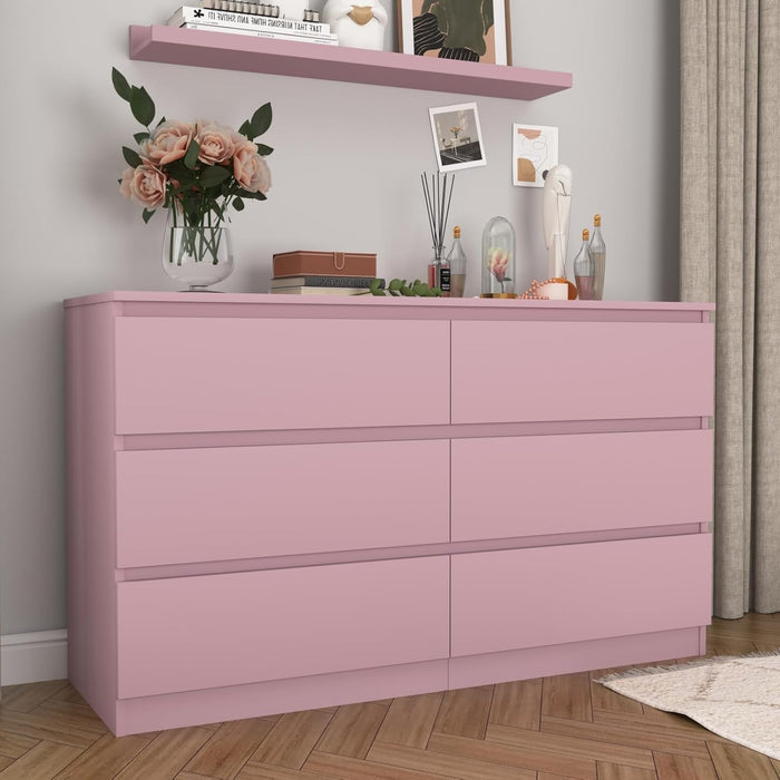 Pink handleless six-drawer dresser in a bedroom