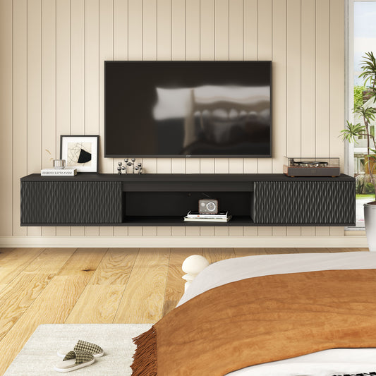 Black floating TV console mounted below a television in a bedroom