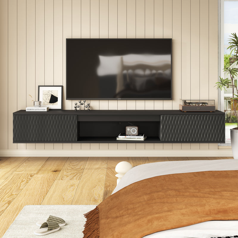 Black floating TV console mounted below a television in a bedroom