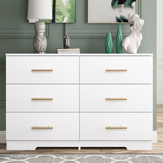 Front view of white dresser with gold-tone pulls against a green wall