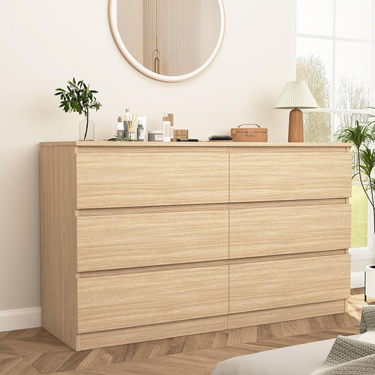 Light brown handleless dresser styled with a mirror in a bedroom